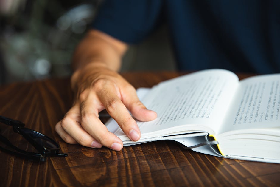 テーブルで本を読んで認識できない男を収穫する