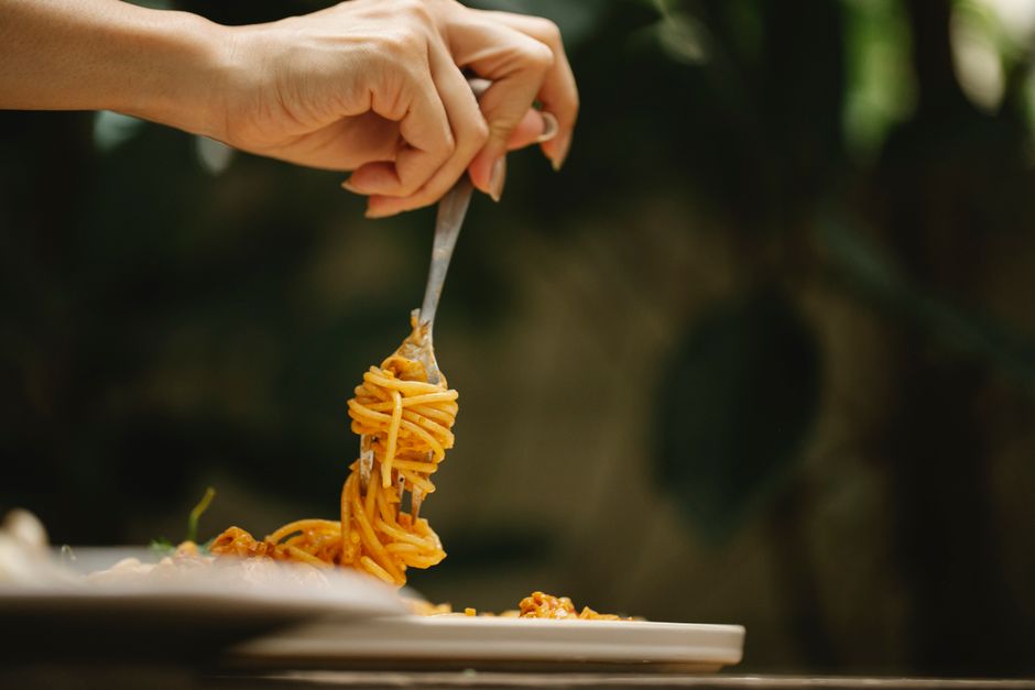 パスタとフォークを持っている人