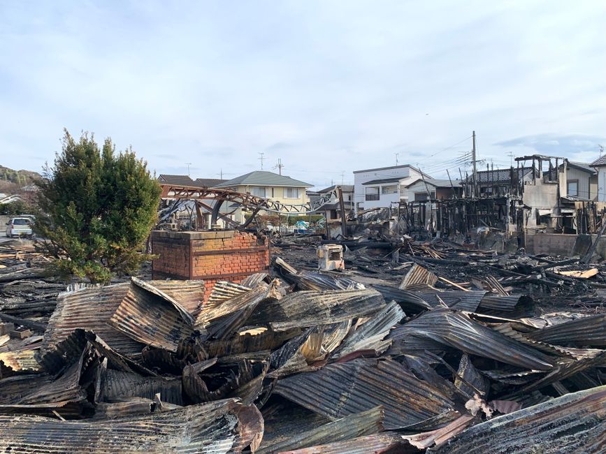 市街地で発生した大火災後の破壊された建物と瓦礫を示す光景。